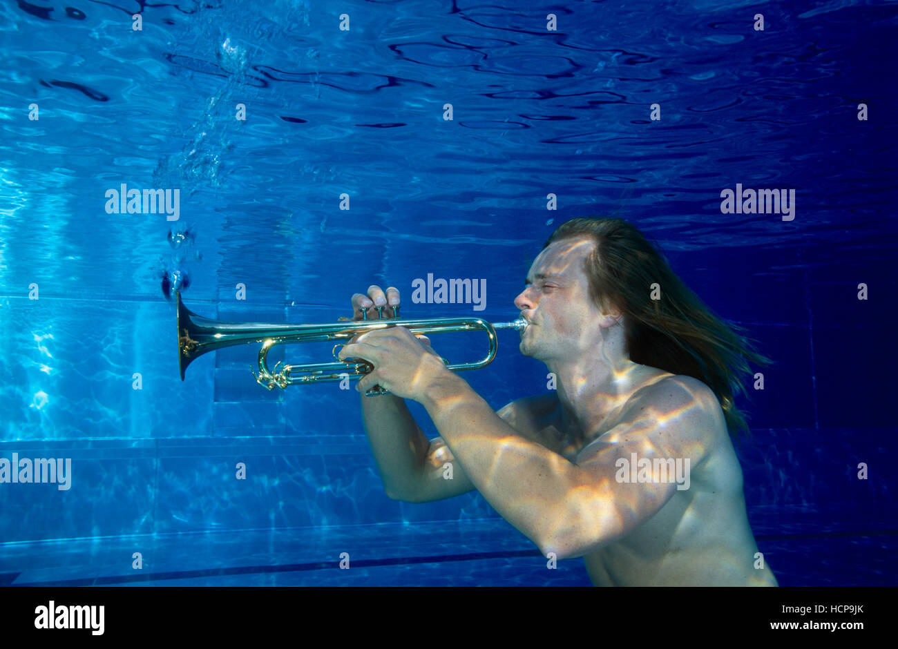 Musician playing trumpet under water Stock Photo