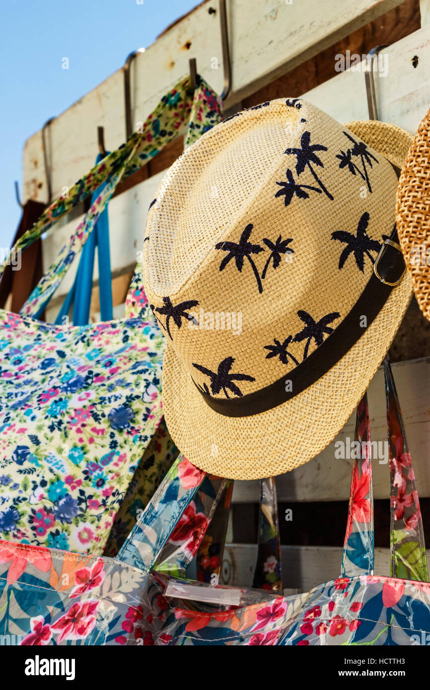 Straw hat with drawings of palm trees in a summer market. Vertical image. Stock Photo