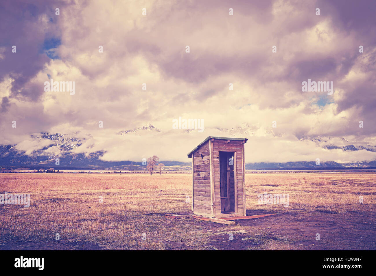 Vintage toned old wooden backcountry toilet in the Grand Teton National Park, Wyoming, USA. Stock Photo