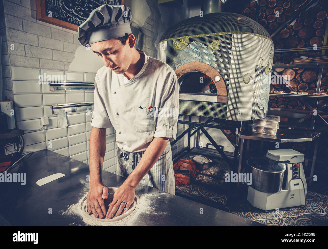 Young chef preparing dough Stock Photo