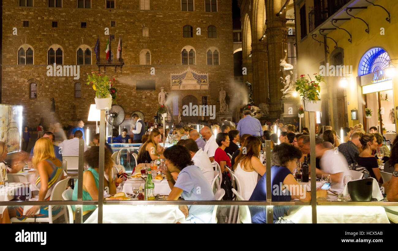 Tourists dinner at luxury restaurant with outdoor cooling misting system, in Piazza della Signoria, Florence, Italy Stock Photo