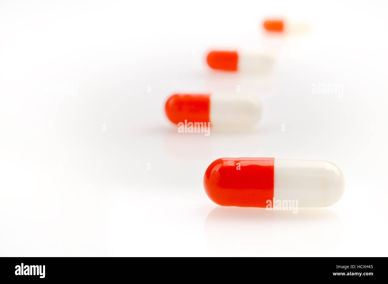Red Medical Capsules on the White Background Stock Photo