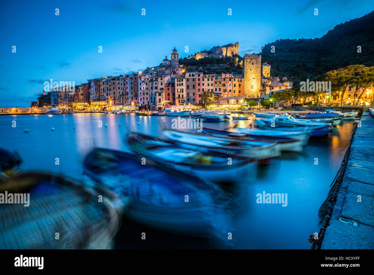 View of blue sea and boats surrounding the colorful village at dusk, Portovenere, UNESCO, La Spezia Province, Liguria, Italy Stock Photo