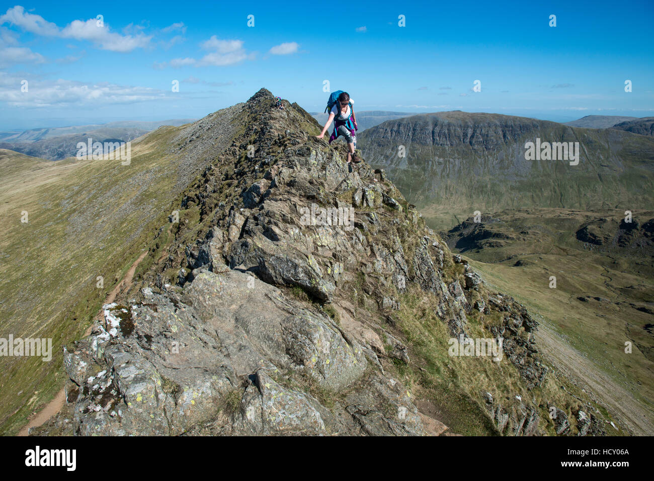 A woman on top of Striding Edge facing towards Ullswater in the English Lake District, Lake District National Park, Cumbria, UK Stock Photo
