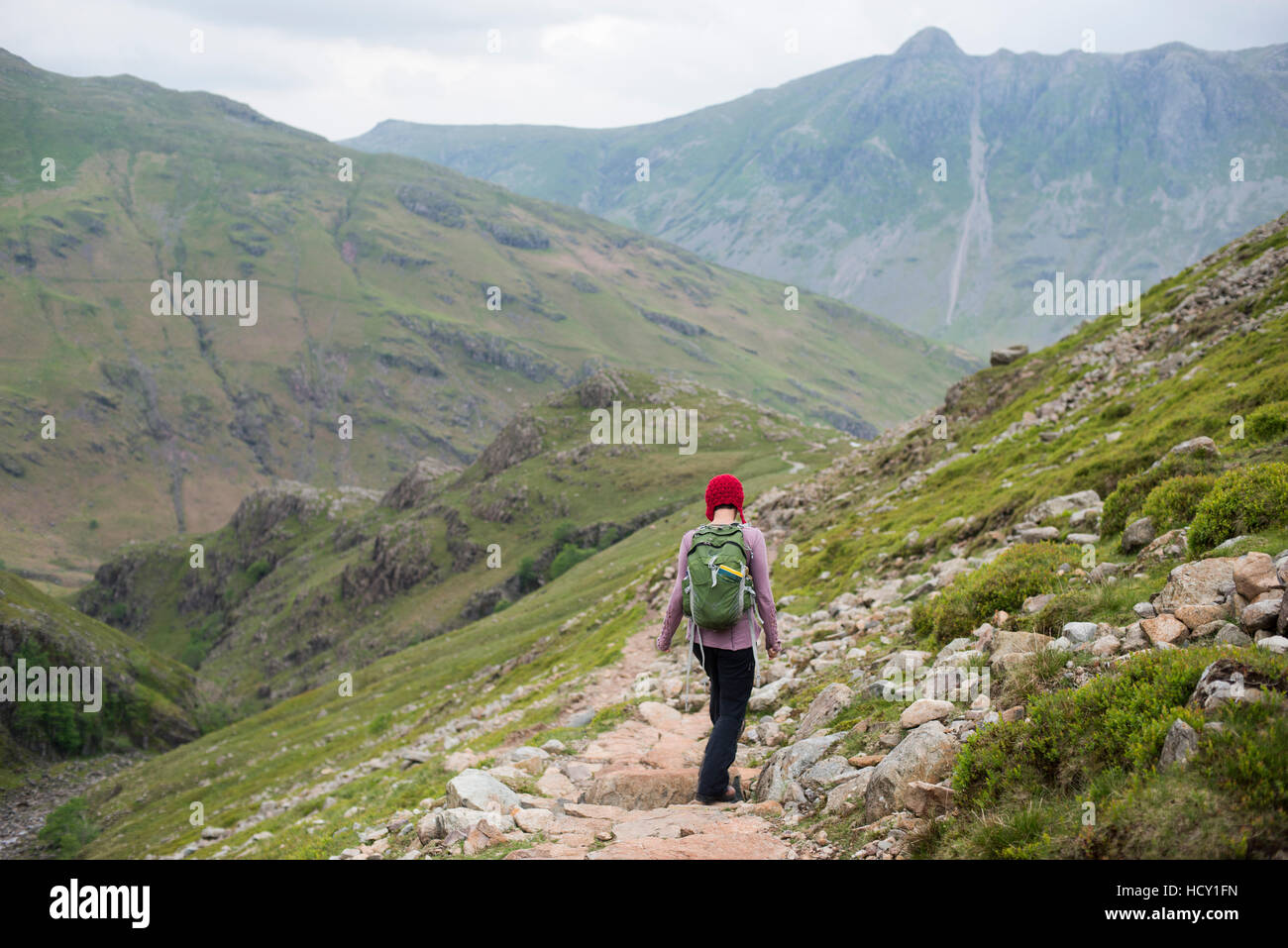 A woman walking down into Great Langdale from Crinkle Craggs, Lake District National Park, Cumbria, UK Stock Photo