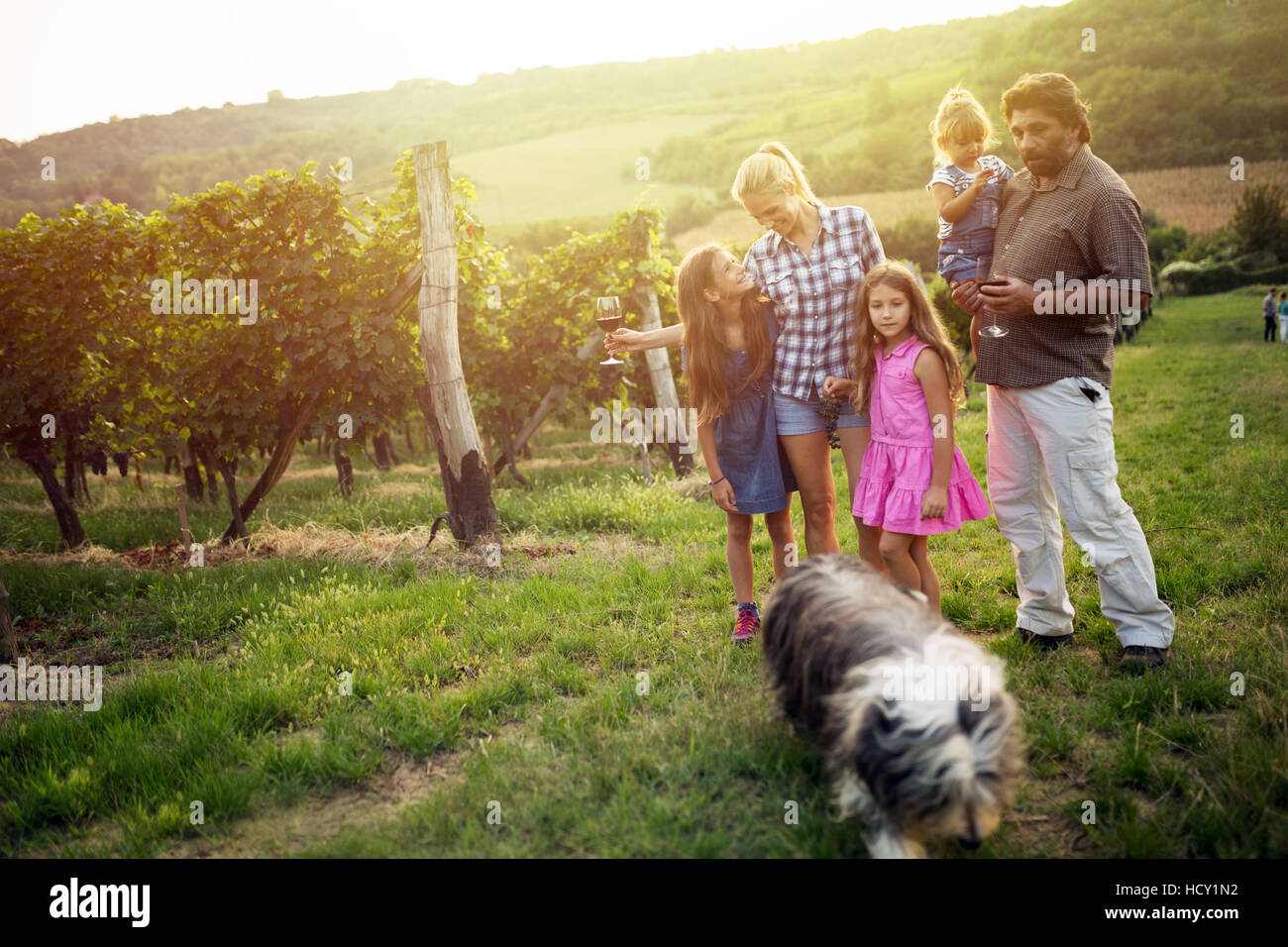 Happy wine grower family walking in vineyard Stock Photo