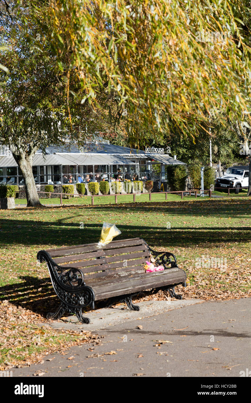 Bench on the Quomps, Christchurch Dorset, with memorial flowers. UK