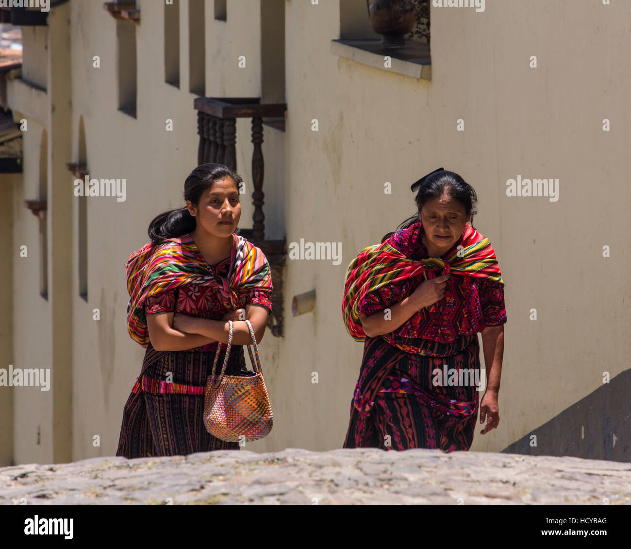 Two Quiche Mayan women, a mother and daughter, in tradtional dress walk up a steep hill in Chichicastenango, Guatemala Stock Photo