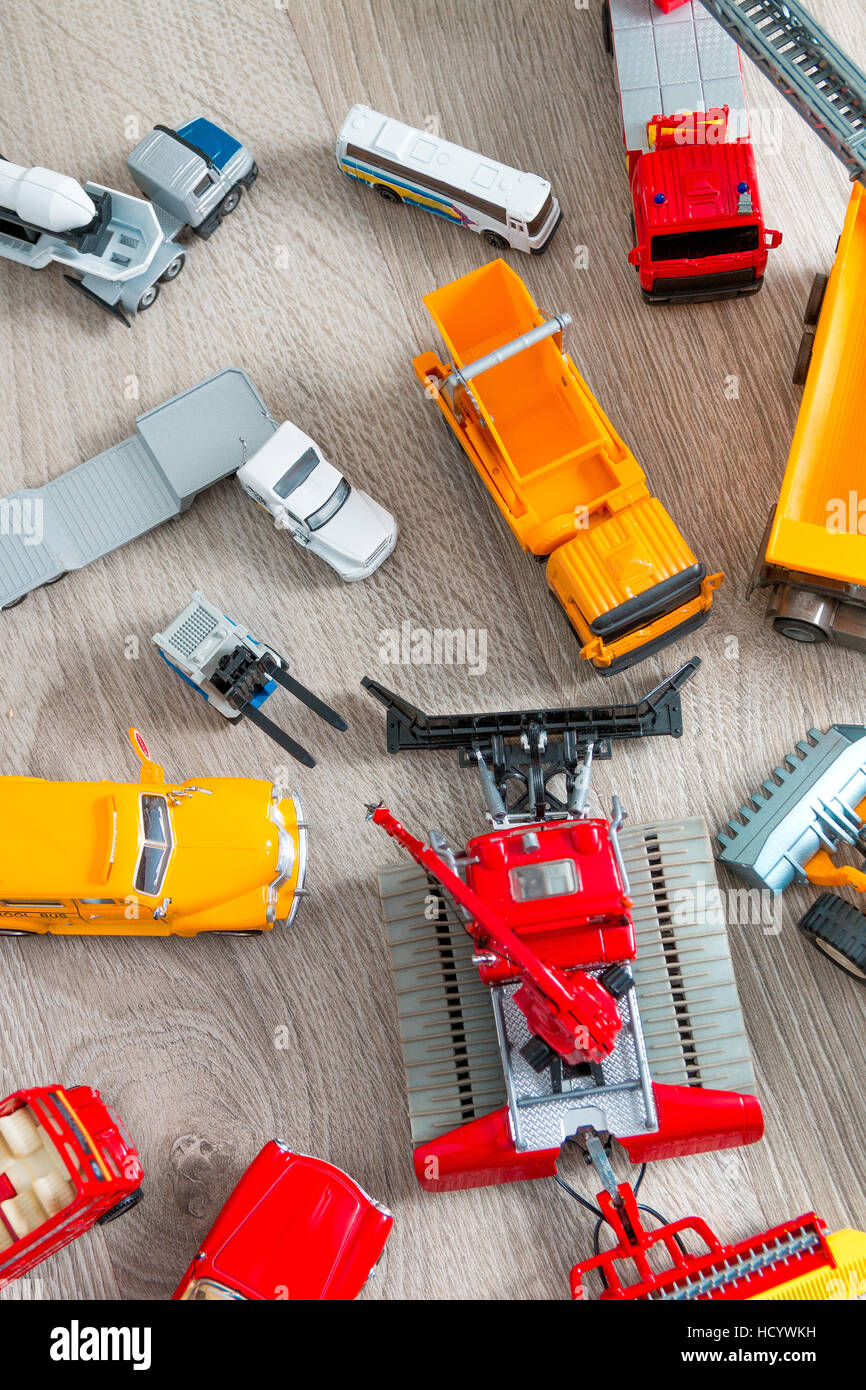 Set of various yellow, red and white car toy on grey wooden background ...