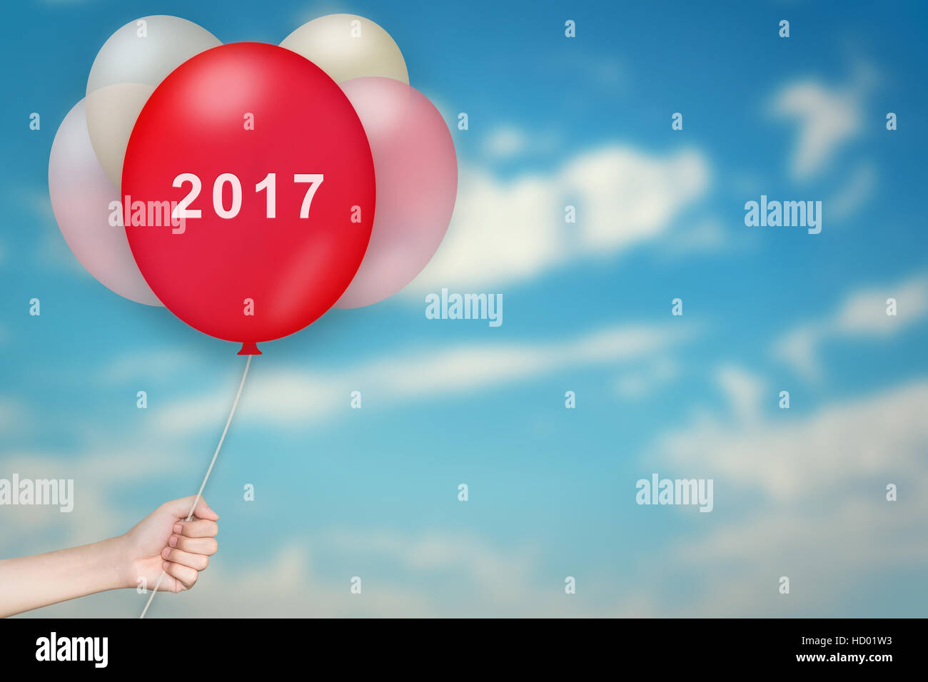 Hand Holding 2017 Balloon with sky blurred background Stock Photo