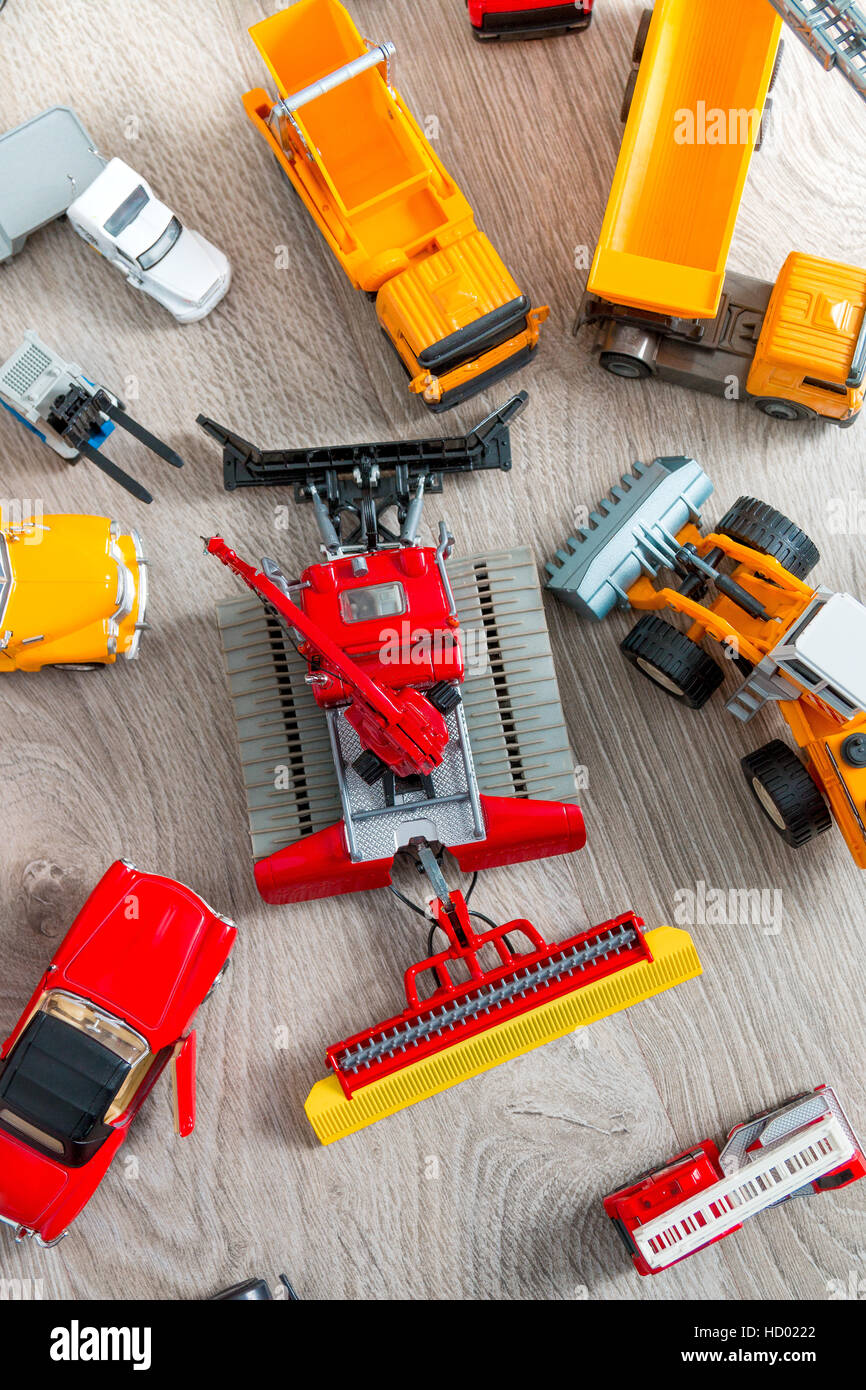 Set of various yellow, red and white car toy on grey wooden background ...