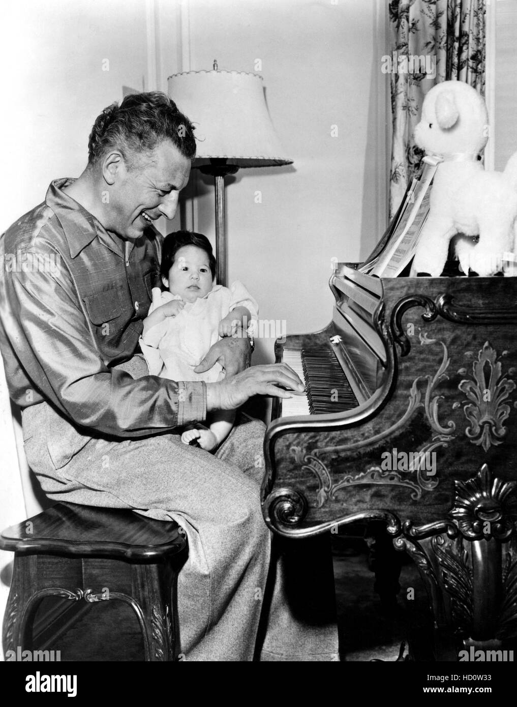 From left: Ezio Pinz holds daughter, Gloria Pinza, while playing piano ...