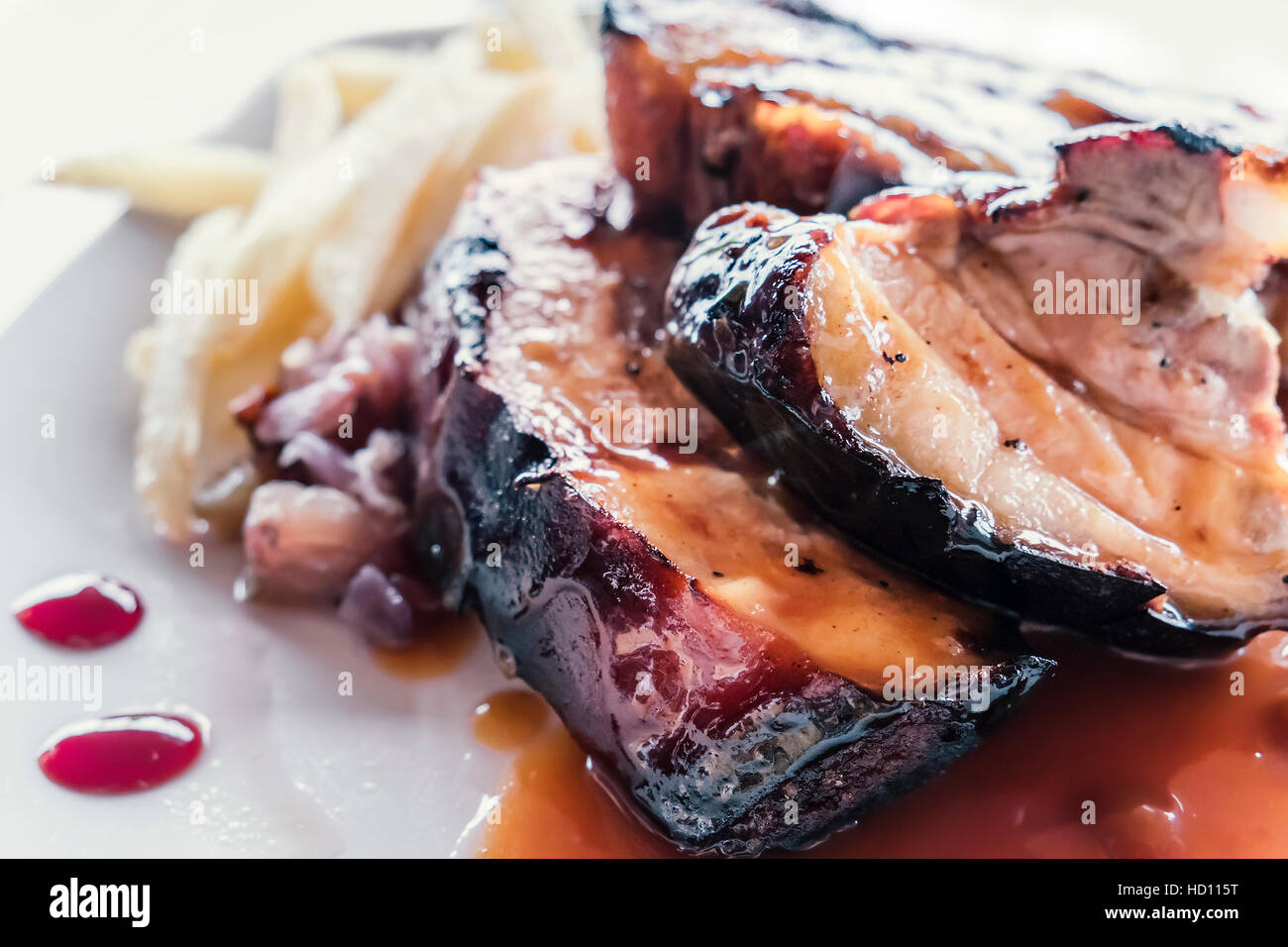 Spanish spare ribs, boned and served with red honey dip and french fries as side dish. Stock Photo