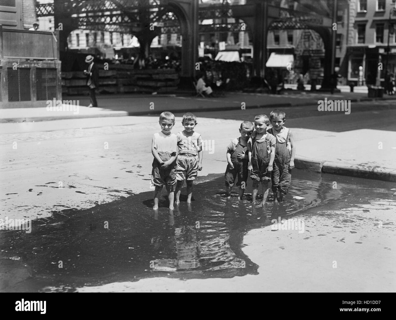 Group of Small Boys Standing in Street Puddle, New York City, New York, USA, Bain News Service, July 1913 Stock Photo