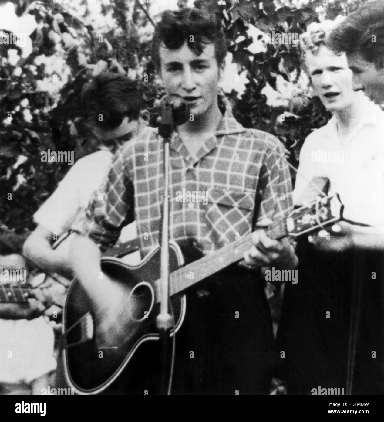 John Lennon at the microphone performing with the Quarry Men Skiffle Group in Liverpool on the day he would meet Paul Stock Photo