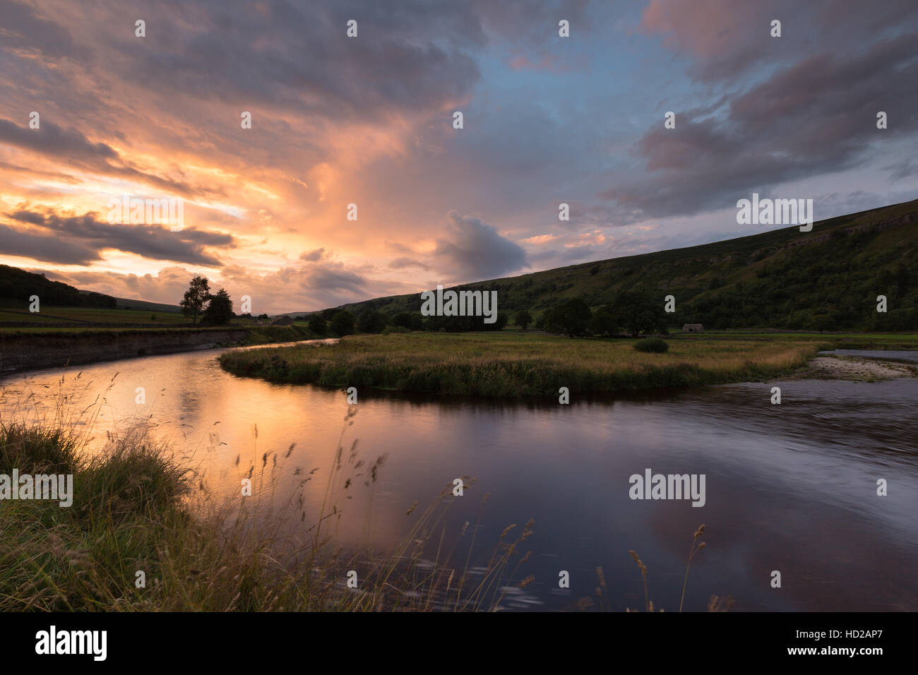 Dramatic sunset and approaching storm is reflected in the River Skirfare below Arncliffe, Littondale, Yorkshire Dales, UK Stock Photo