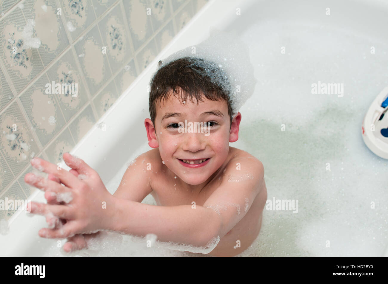 young boy in a bath full of bubbles Stock Photo Alamy