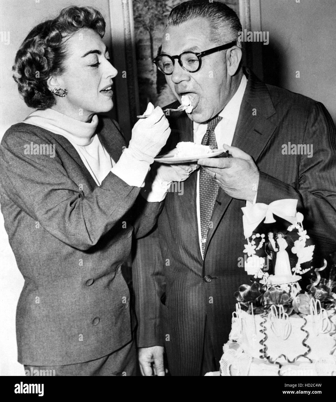Joan Crawford and her husband Alfred Steele share wedding cake, May 13,  1955 Stock Photo - Alamy