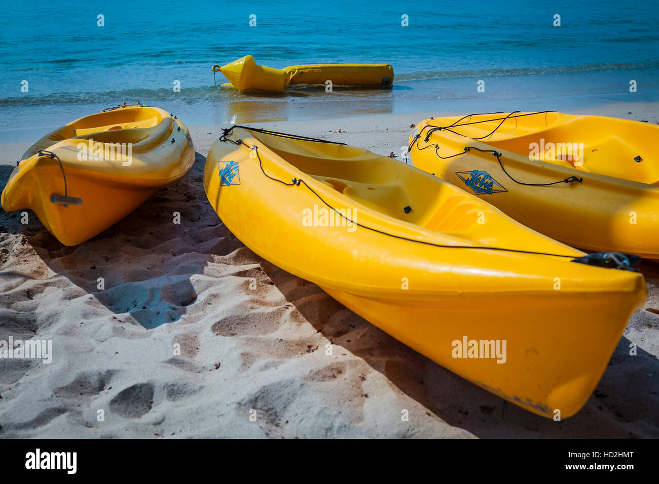 3 yellow kayaks on sandy beach Stock Photo