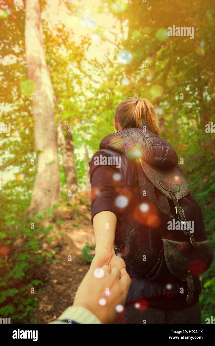 People follow one another in a magical forest Stock Photo - Alamy