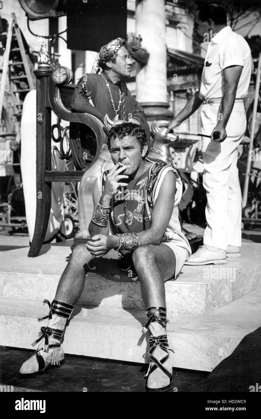 cigarette burton Richard Burton takes a cigarette break during filming of Cleopatra, 1963.  Rex Harrison is seated at rear Stock Photo