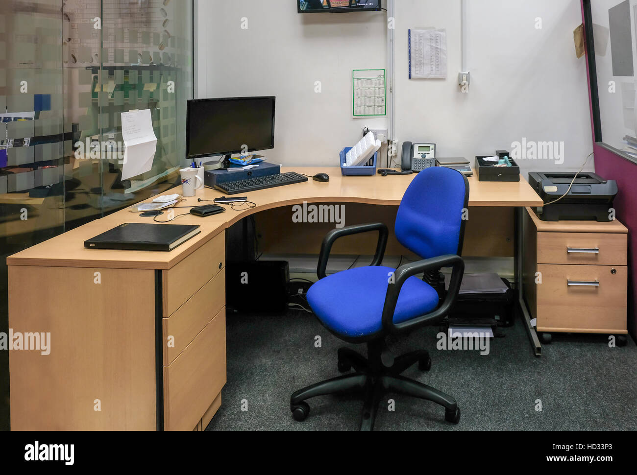 Working desk with telephone, computer and swivel chair.  Its taken in my shop and although tidy you can see its a busy place. Stock Photo