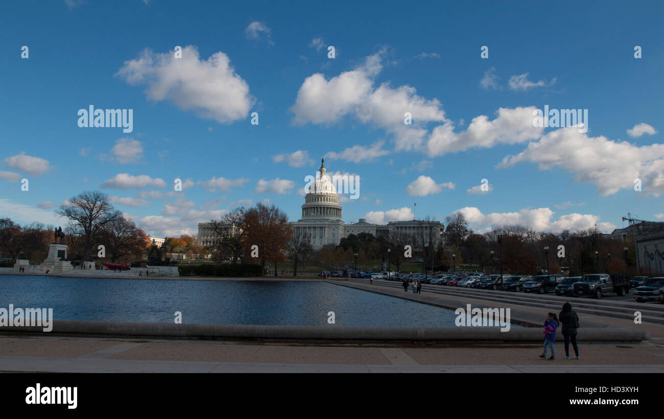 U.S. Capitol, west front, on a sunny winter day, with puffy clouds. Reflecting pool is in foreground. Dome is newly cleaned. Stock Photo