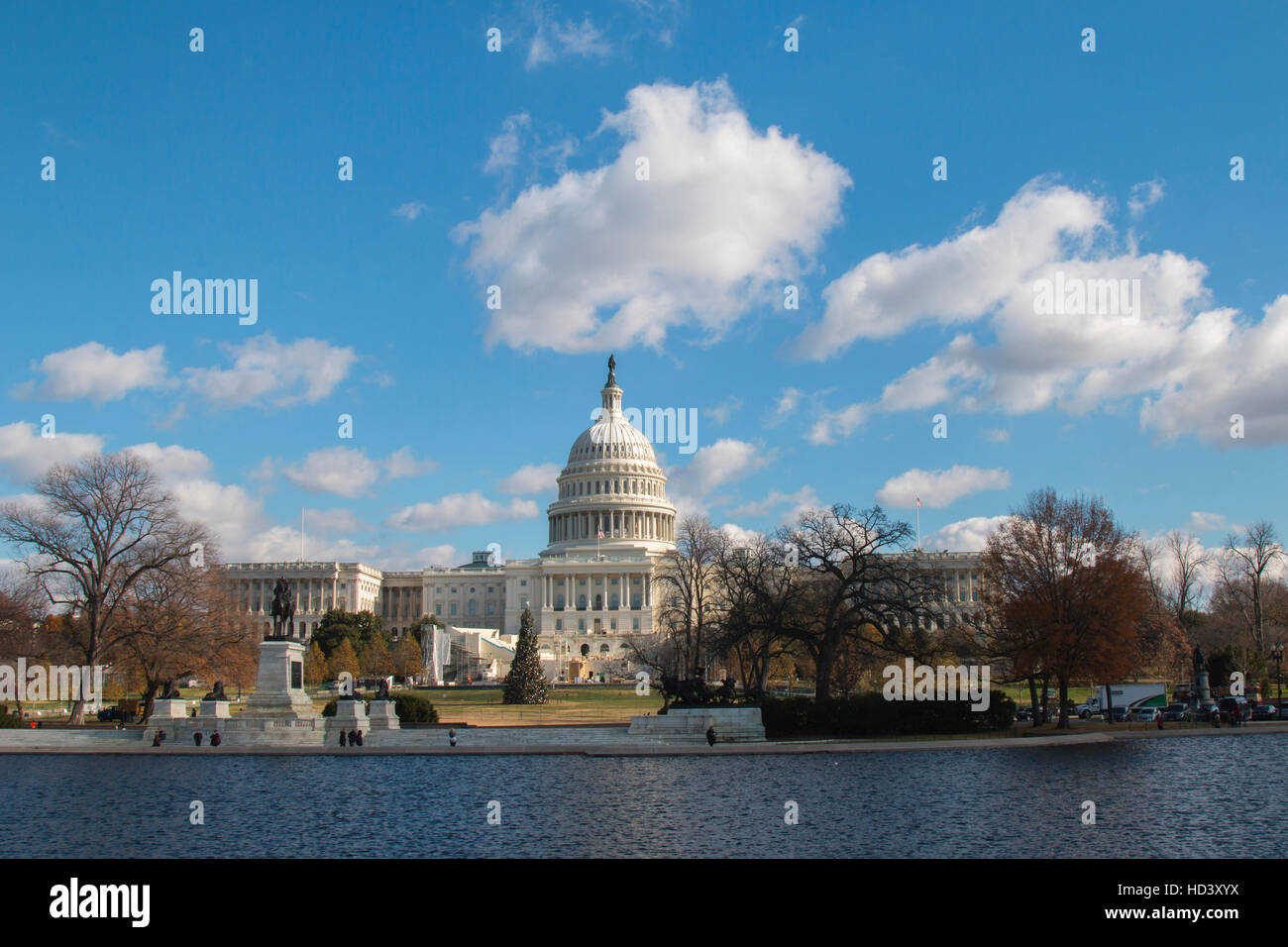 U.S. Capitol, west front, on a sunny winter day, with puffy clouds. Reflecting pool is in foreground. Dome is newly cleaned. Stock Photo