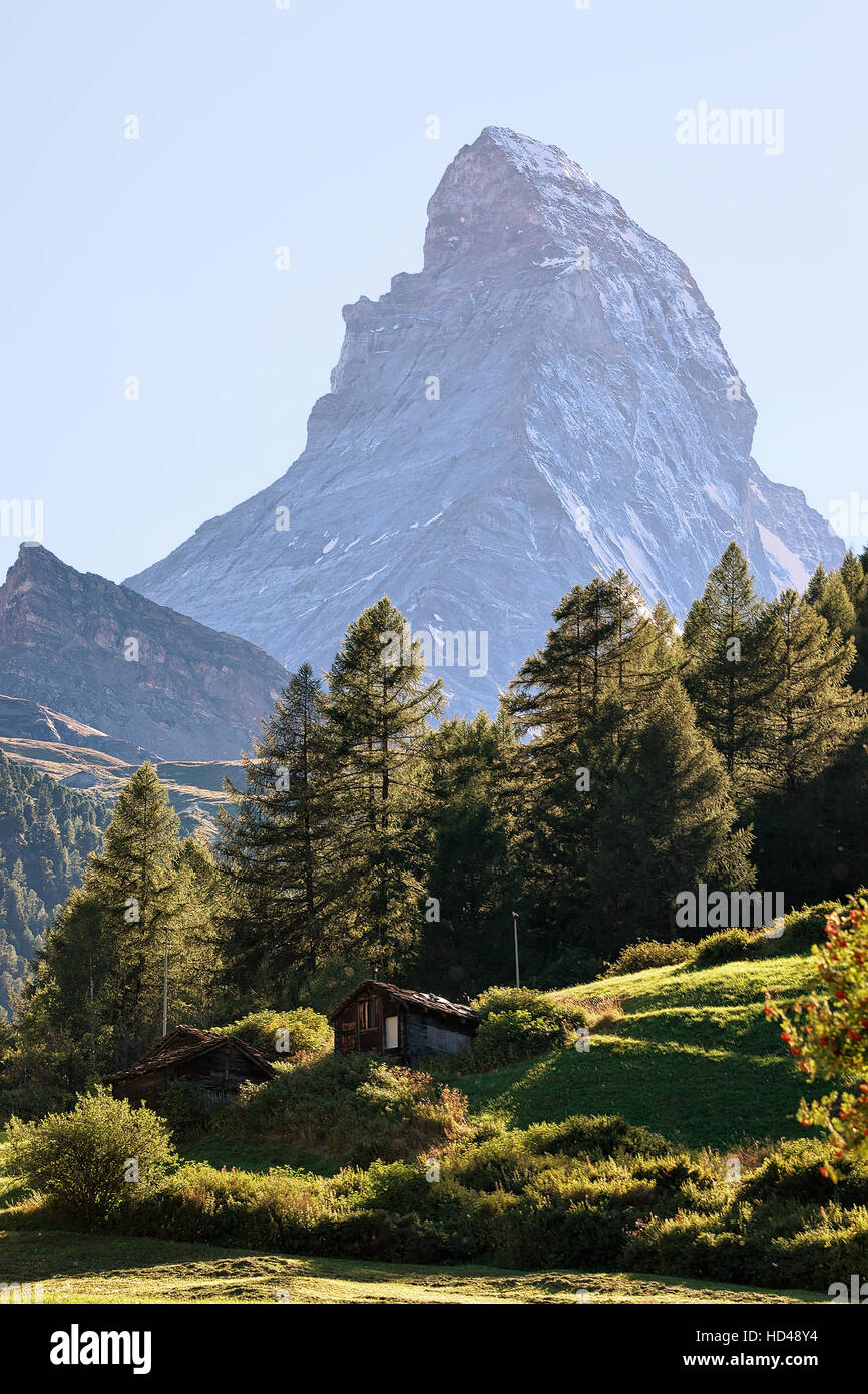 Matterhorn mountain and green valley with traditional Swiss chalet in ...