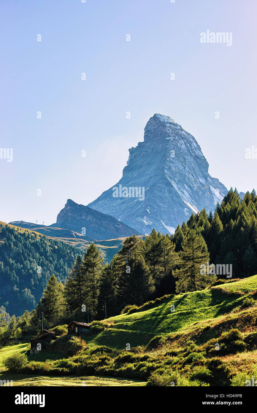 Matterhorn mountain and green valley with chalets in Zermatt, Switzerland in summer. Stock Photo