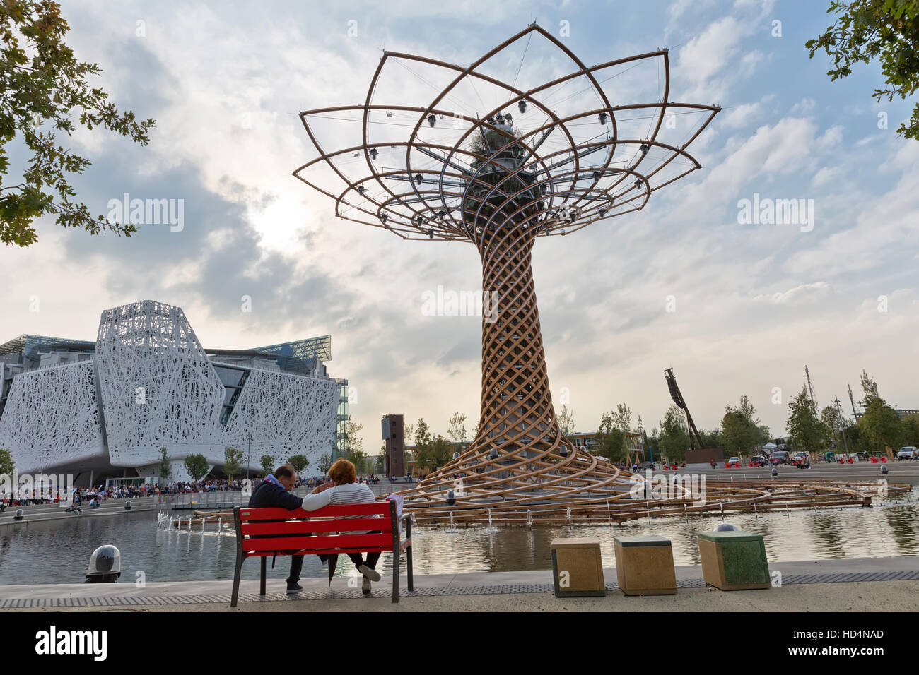 MILAN, ITALY - September 2015: Couple sitting in front of Italian pavilion at Expo 2015. The theme of the Universal Exposition is Feeding the Planet,  Stock Photo