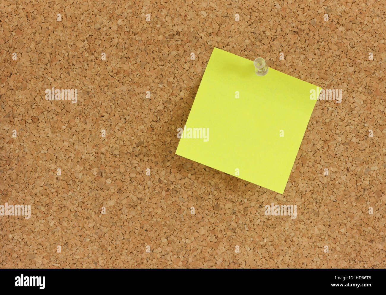 Yellow post-it note memo pinned to a pin board Stock Photo