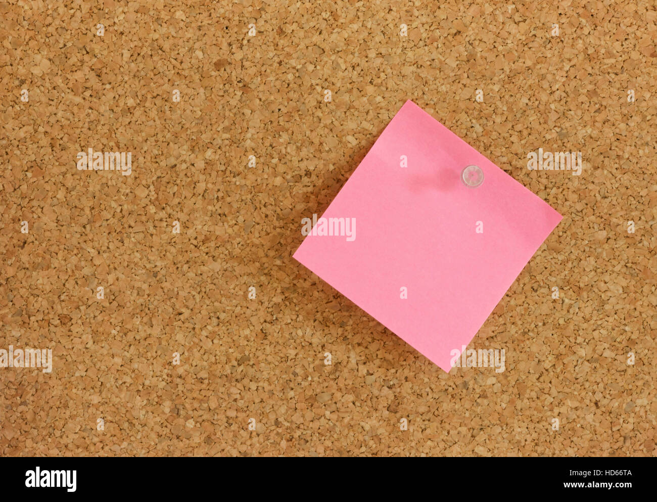 Pink post-it note memo pinned to a pin board Stock Photo