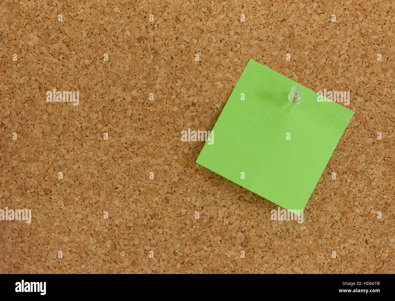 Green post-it note memo pinned to a pin board Stock Photo