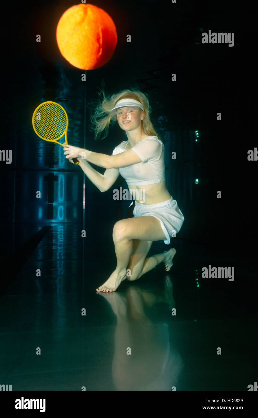 Woman playing tennis underwater Stock Photo
