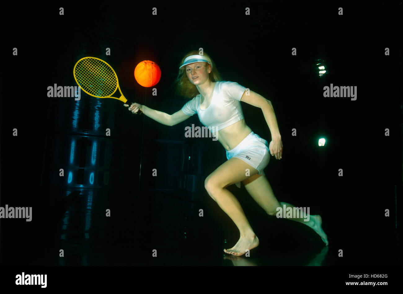Woman playing tennis underwater Stock Photo
