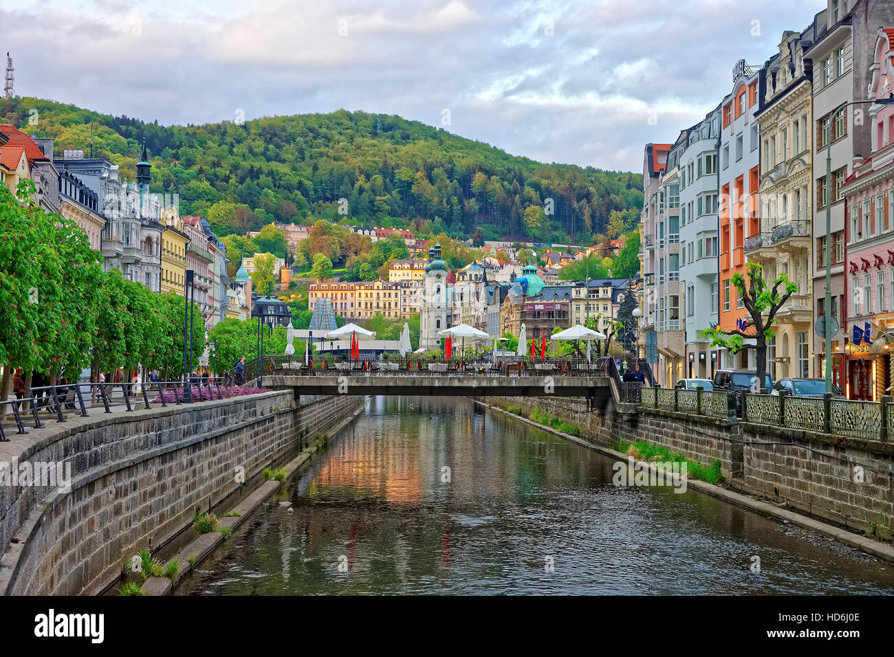 Karlovy vary, Czech republic - May 5, 2014: Tepla River embankment and Saint Mary Magdalene Church in Karlovy Vary, Czech republic. People on the back Stock Photo