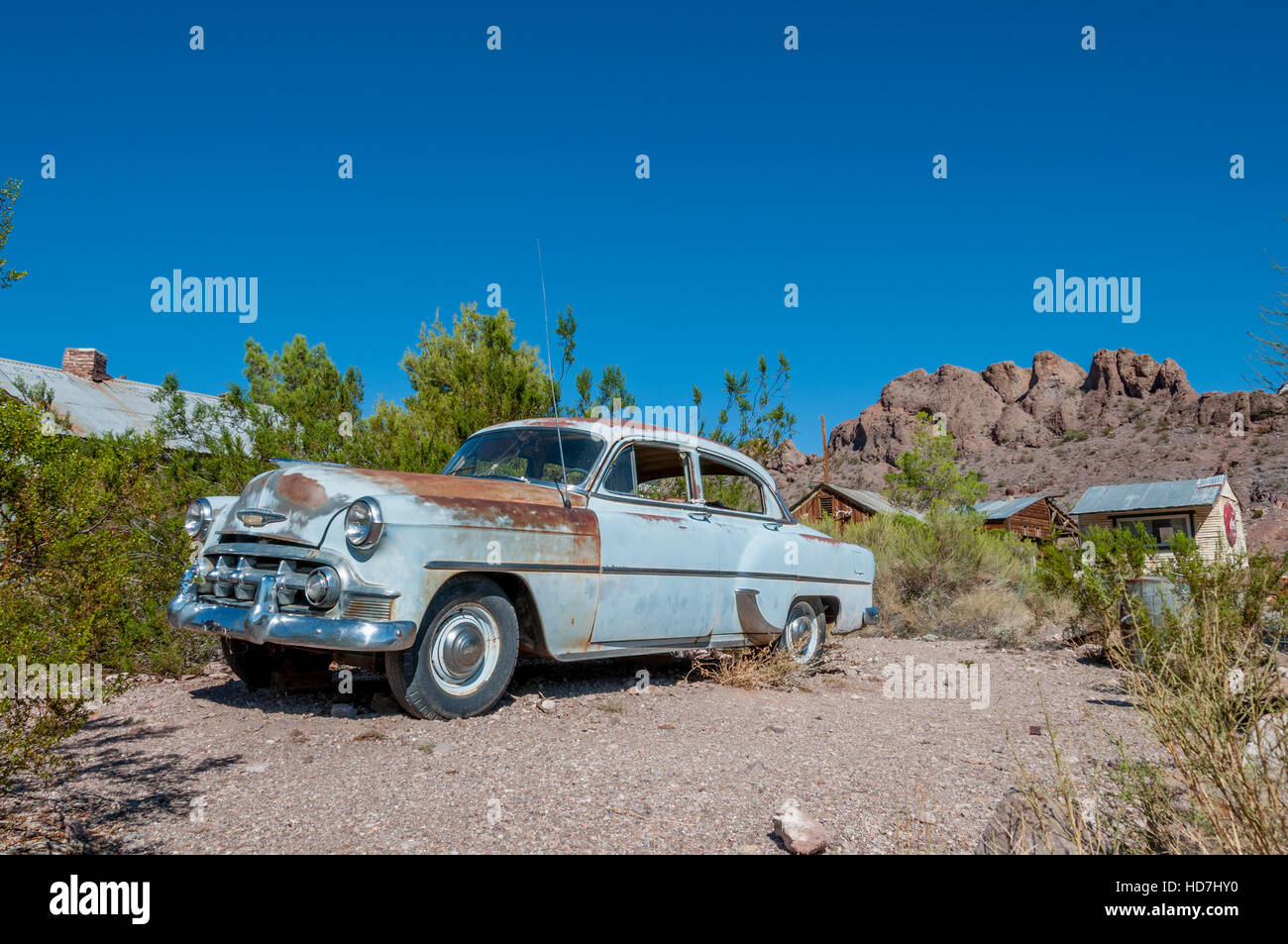 Early 1950s Chevy car light blue with rust abandoned in desert ghost town and movie set at Techatticup Mine in Nevada near Route 66. Stock Photo