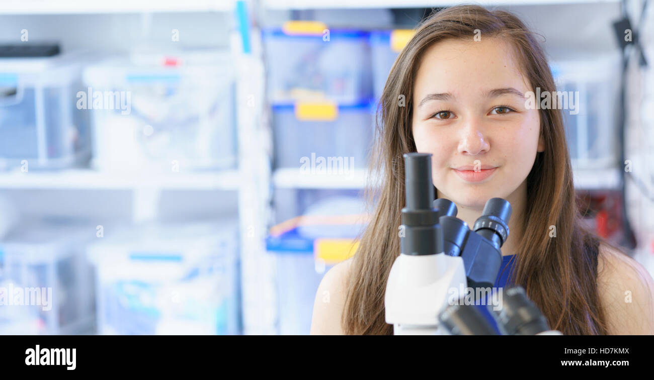 MODEL RELEASED. Girl with microscope in laboratory Stock Photo - Alamy