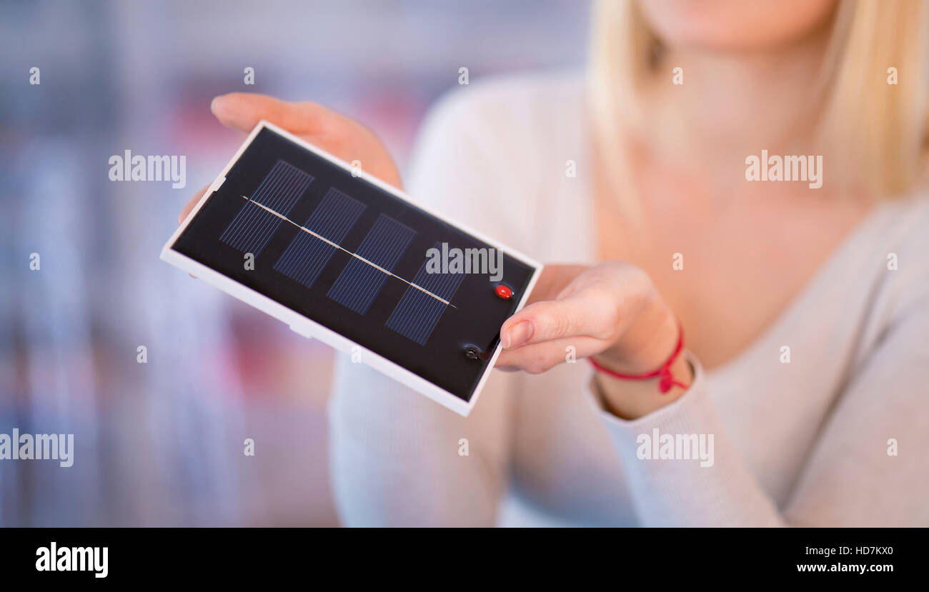 MODEL RELEASED. Woman holding solar photovoltaic cell. Stock Photo
