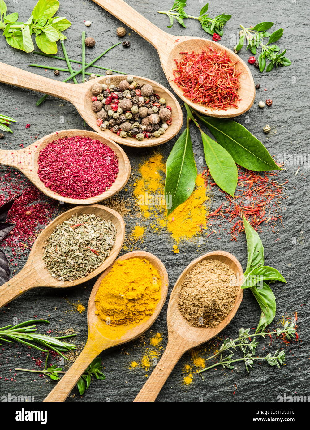 Assortment of colorful spices in the wooden spoons. Stock Photo