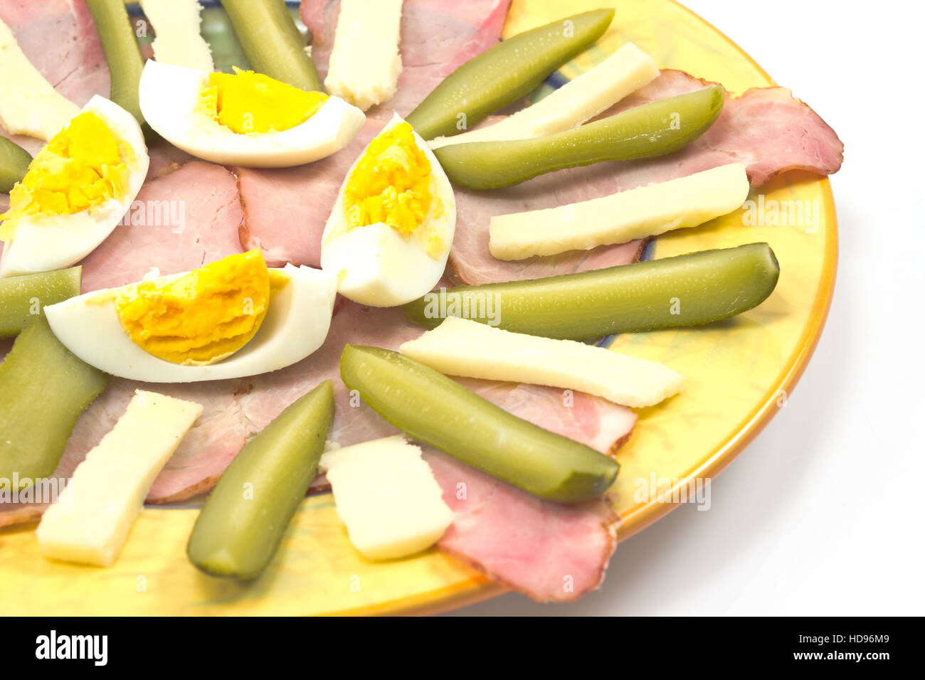 Meat delicatessen with egg and chees on plate on white Stock Photo