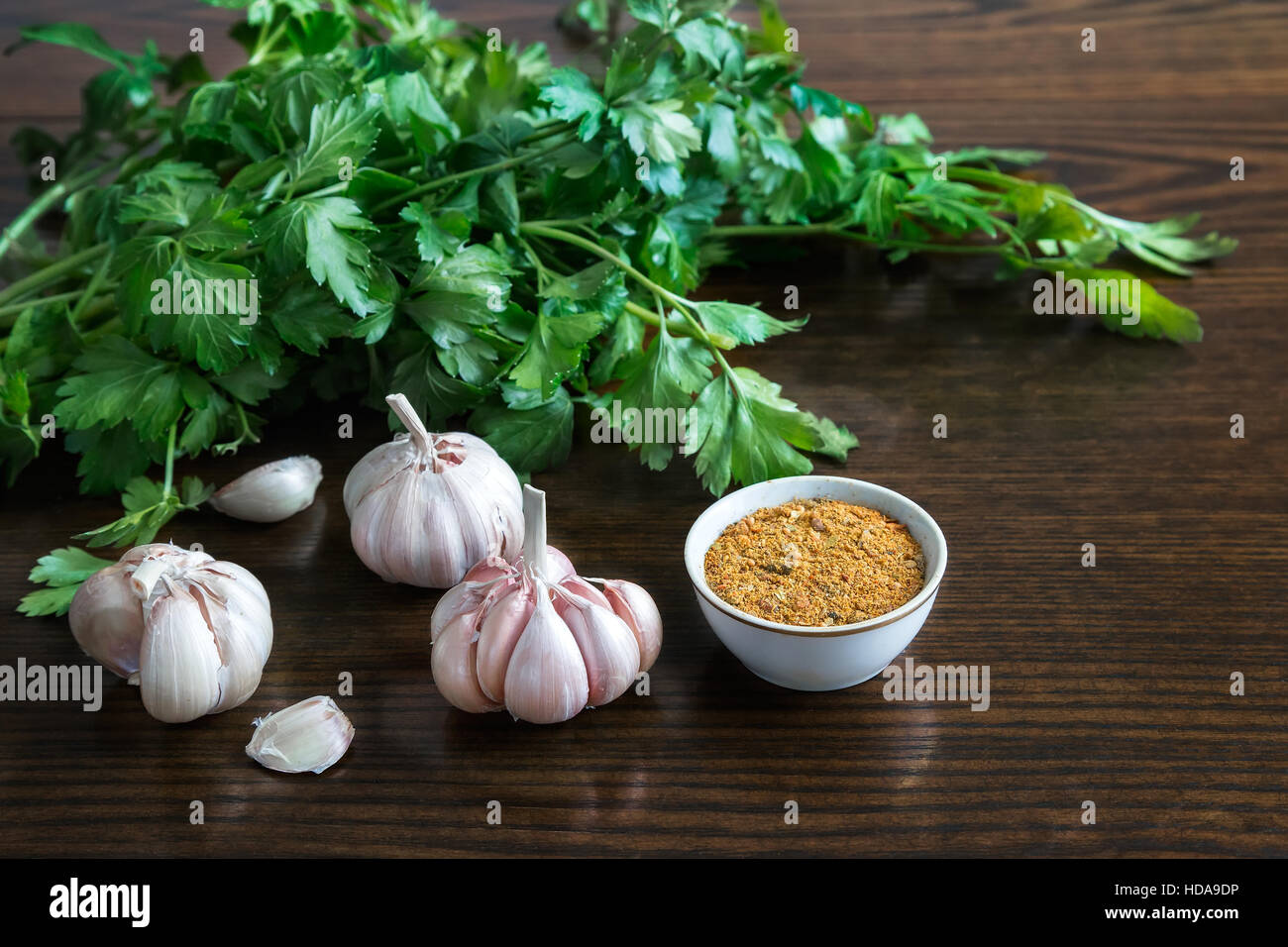 On the table lay the parsley leaves, spices and garlic. ( Photo in the