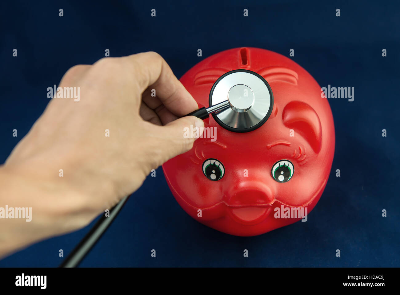 Piggy Bank and Stethoscope with Selective Focus on a blue Background. Stock Photo