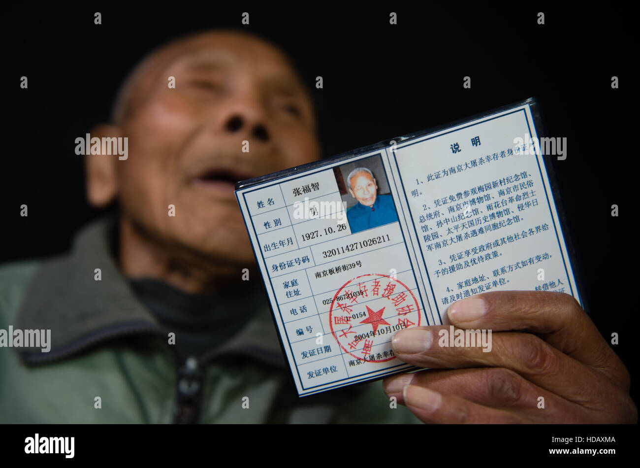 (161211) -- NANJING, Dec. 11, 2016 (Xinhua) -- Zhang Fuzhi demonstrates a certificate of survivors of the Nanjing Massacre, Nov. 16, 2016. Zhang Fuzhi, born in October of 1927, was beat up by invading Japanese soldiers in 1937. His right eye went blind. He passed away on Nov. 26, 2016. Japanese troops occupied eastern China's Nanjing on Dec. 13, 1937, and began a six-week massacre. Chinese records show more than 300,000 people -- not only disarmed soldiers but also civilians -- were brutally murdered and thousands of women raped. In the past 79 years, the number of survivors decreases. After Z Stock Photo