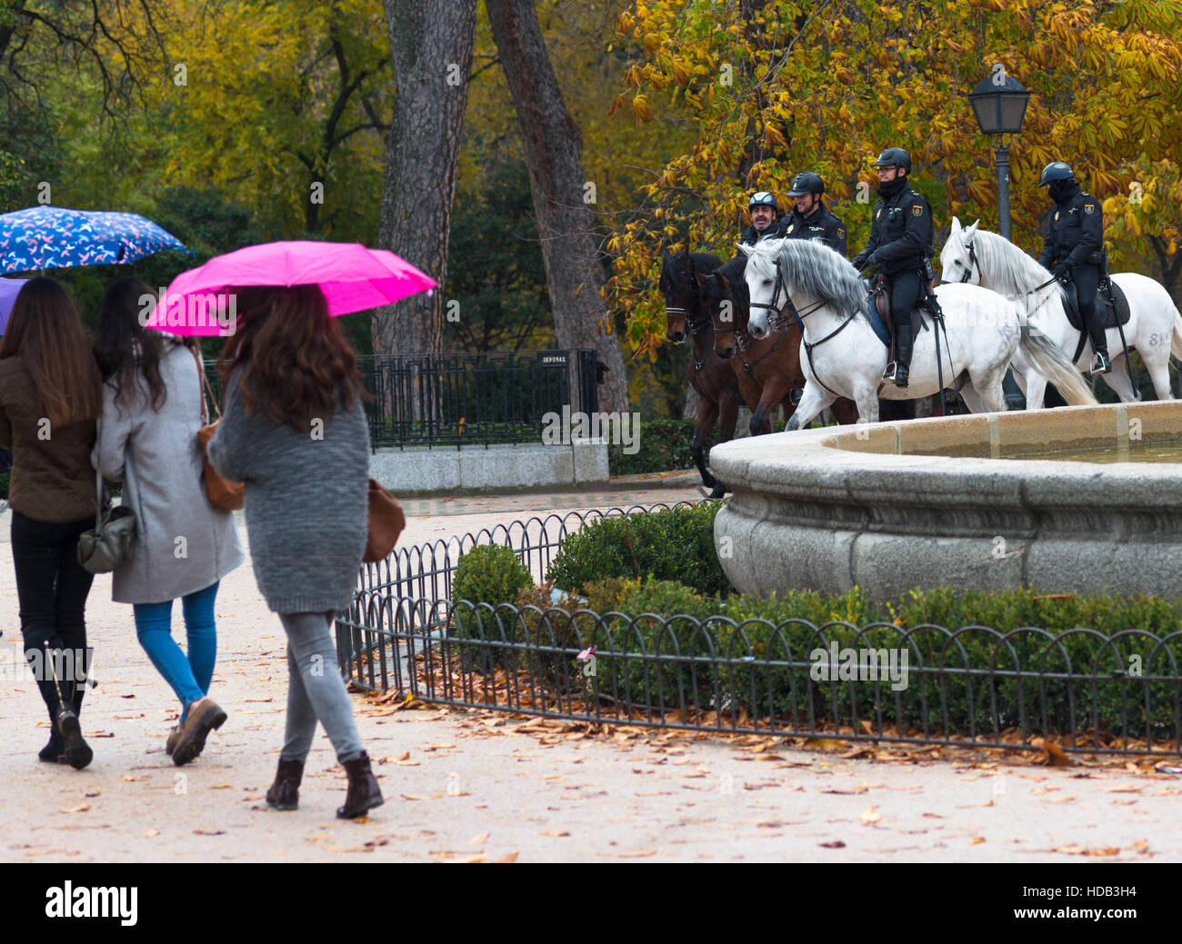 Fountain within Retiro park in Madrid, Spain with two police horse passing by. Stock Photo