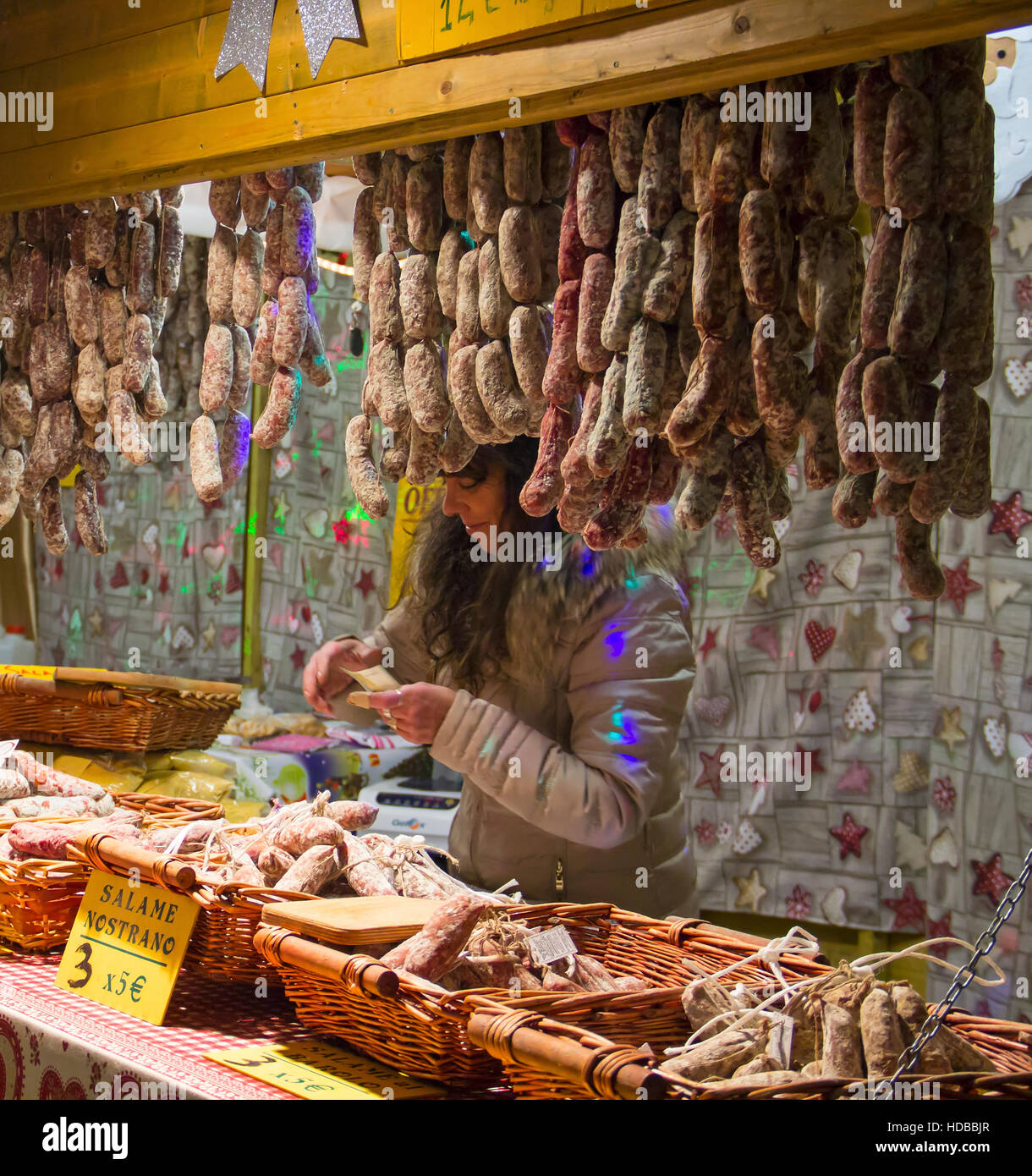 COMO, ITALY - DECEMBER 2, 2016: Woman sells salami sausages at winter Christmas market Stock Photo