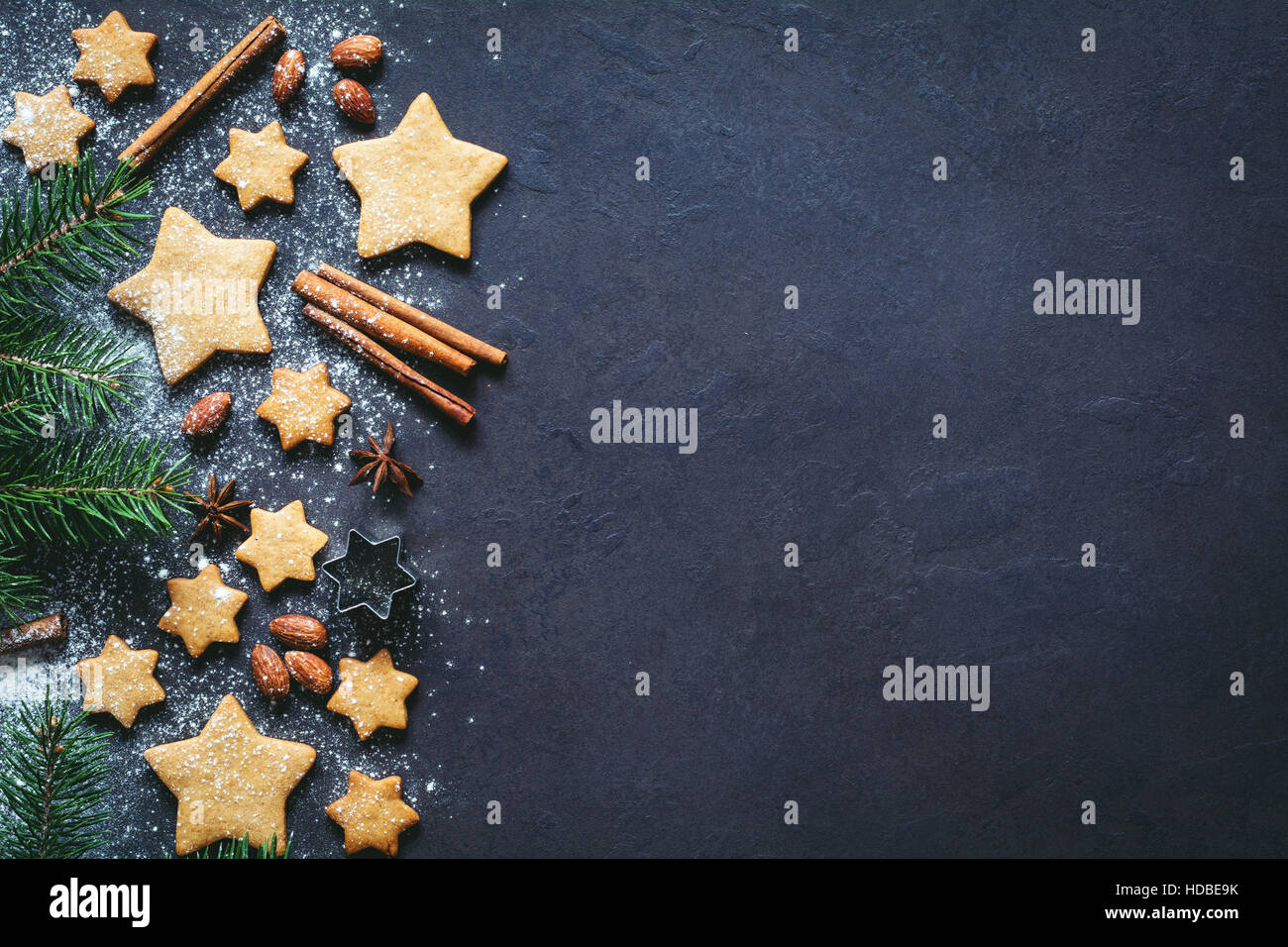 Christmas or New Year background with gingerbread cookies, spices, nuts, flour and fir tree. Copy space for text Stock Photo