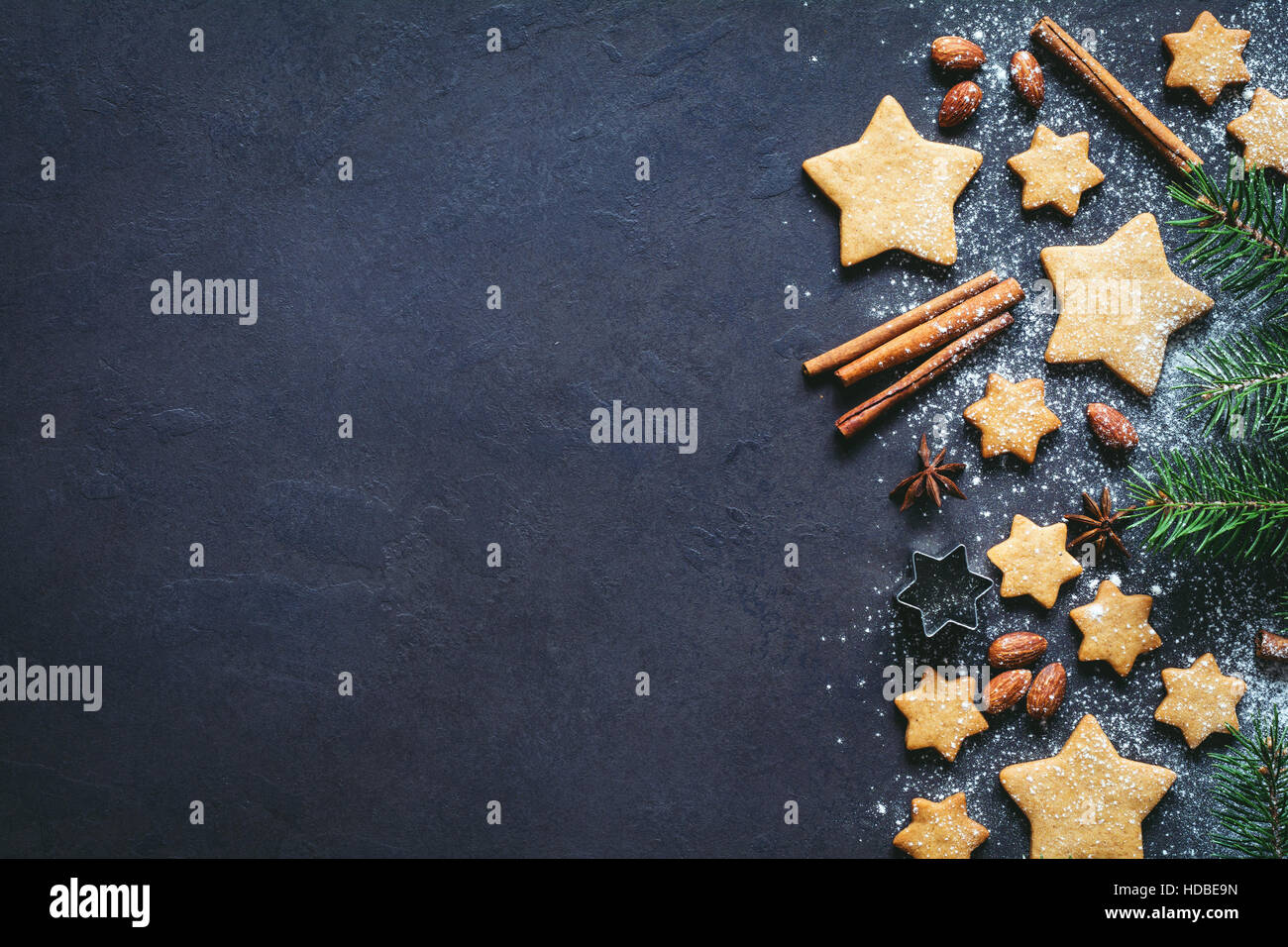 Christmas or New Year background with gingerbread cookies, spices, nuts, flour and fir tree. Copy space for text Stock Photo