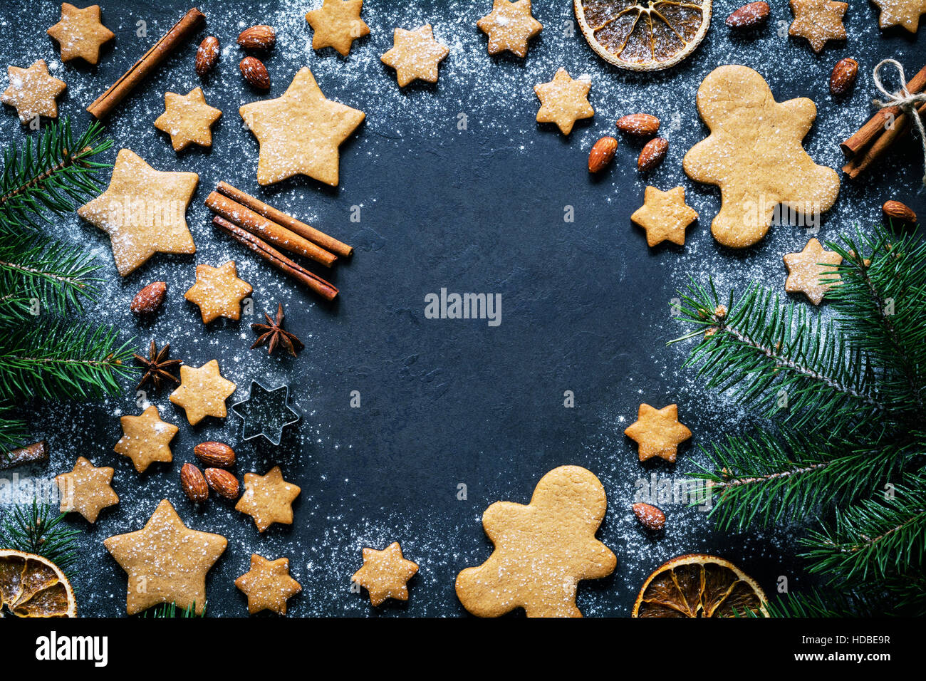Christmas or New Year background with gingerbread cookies, gingerbread man cookies, stars, spices, cinnamon and fir tree Stock Photo